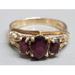 A 9ct yellow gold and garnet three stone ring, size P 3.63g gross.