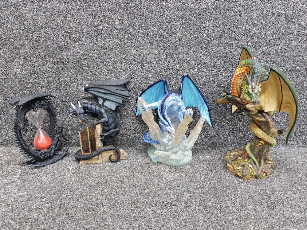 Three Land of the Dragons resin sculptures together with a sand timer with dragon decoration.