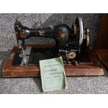 An antique Cylinder Shuttle sewing machine in wooden box, with key.