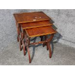 A nest of reproduction mahogany tables, with X frame supports.