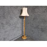 A light oak standard lamp with cream shade.