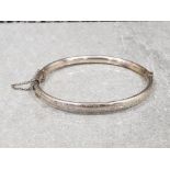 Ladies silver hindged bangle with engraved pattern . 7.6 g