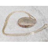 Ladies silver oval locket + chain , comprising of a oval locket with engraved pattern + curb chain .