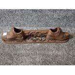 A cast metal boot scraper with shoe decoration 43cm wide.