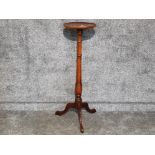 A reproduction mahogany circular plant stand raised on tripod legs 98.5cm high.