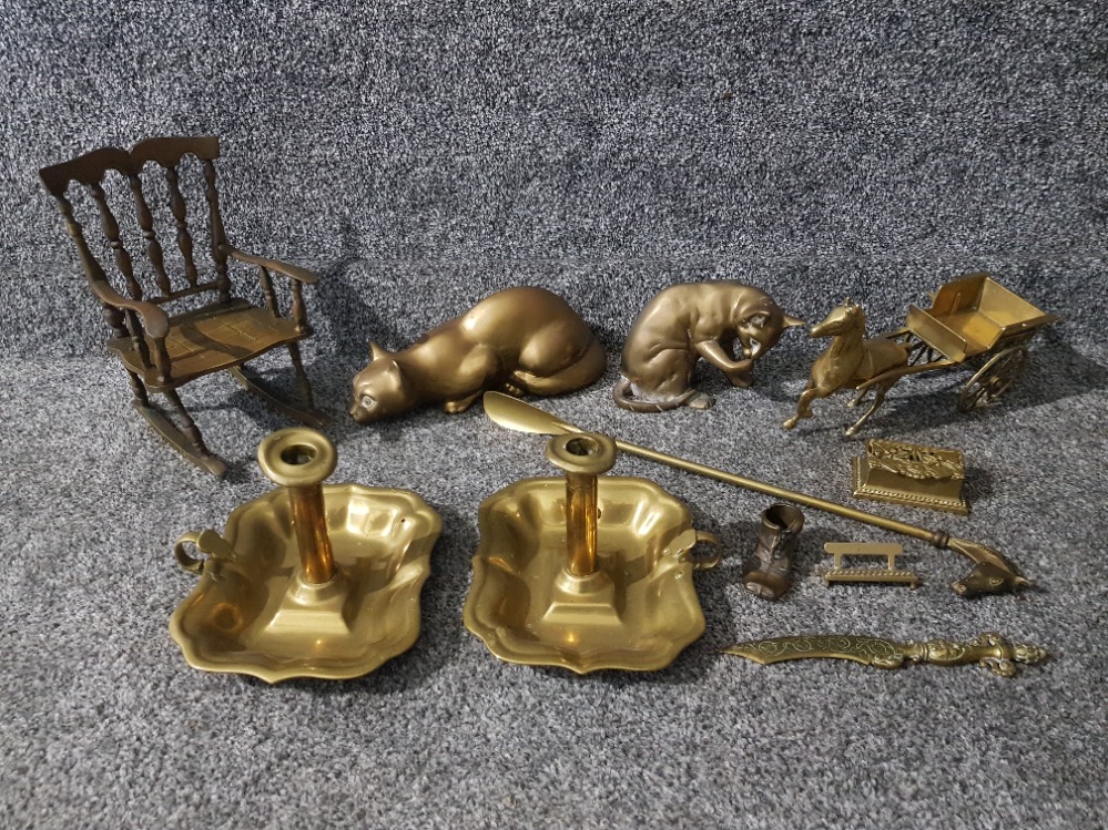 Brass items to include cat sculptures, a pair of chambersticks, shoe horn etc.