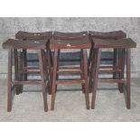 A set of six stained wood bar stools.