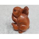 A finely carved Chinese hardwood netsuke depicting two rabbits.