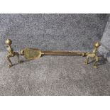 A pair of brass andirons and a part fireside companion set.