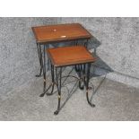 A conservatory nest of two wood and metal tables.