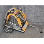 A bike buggy in orange and grey.
