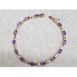 9ct yellow gold bracelet set with 11 purple stones, 6g gross