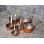 Set of 6 copper pans with brass handles, various sizes