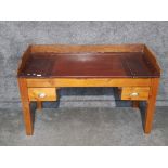 A large pine writing desk fitted with two drawers with brass handles 142 x 90 x 63cm.