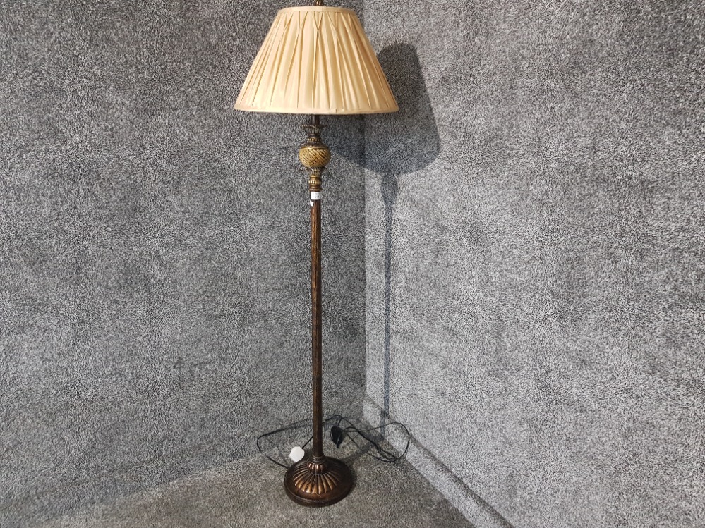 A lacquered metal standard lamp with beige shade.