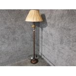 A lacquered metal standard lamp with beige shade.