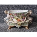 A Meissen style centre piece decorated with garlands and putti 29cm wide.