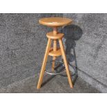 A modern beech adjustable stool with metal band.