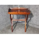 A reproduction mahogany butler's tray on folding stand.