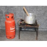 A 19kg propane calor gas can, an outdoor gas cooker and a large aluminium saucepan with two wooden