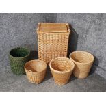 A wicker laundry basket and four wicker bins.