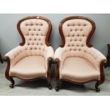 A pair of French walnut open armchairs upholstered in pink material.