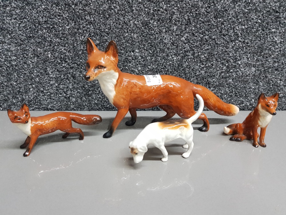 Three Beswick foxes and a hound.