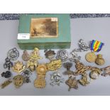 Box containg 25 different military cap badges plus WWI civilisation medal with original ribbon