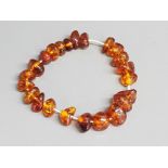 An amber bracelet (needs re-stringing) 21.3g.