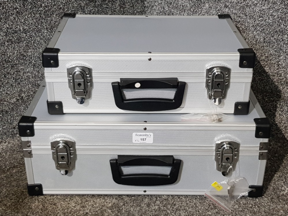 Two heavy duty suitcases with keys.
