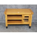 An oak TV unit with glazed cupboard door.