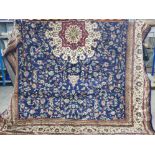 A large Persian wool rug with floral motifs on blue ground 370 x 270cm.