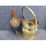 A brass coal scuttle and a set of bellows.