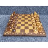 Large wooden travel chess board with carvings to base, complete with hand carved wooden pieces