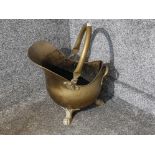 A Victorian brass coal scuttle raised on paw feet.