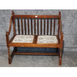 A two seater wooden hall chair with drop in seats.