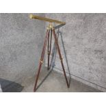 antique brass telescope on adjustable wooden tripod base