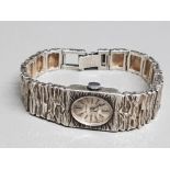 A ladies accurist solid silver bracelet wristwatch of bark design 37.5g gross, in original box.