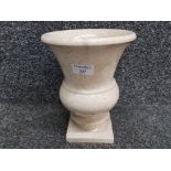 A marble urn on square shaped base 24cm high.