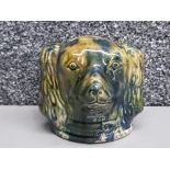An antique pottery money box in the form of a Spaniel head.