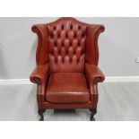 Metal studded red leather chesterfield wing back armchair