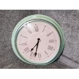 A large IKEA wall clock with green painted metal frame.