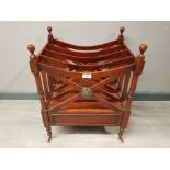 A mahogany empire style canterbury raised on castors.