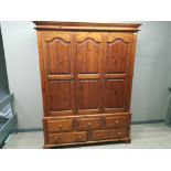 Large stained pine triple door wardrobe, fitted with 5 drawers beneath, 157x64cm, height 209cm