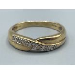 Ladies 9ct gold Diamond crossover ring. Comprising of 7 round brilliant cut diamonds. 2.1g size O1/