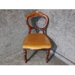 A Victorian mahogany balloon back dining chair upholstered in green velour.