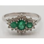 Ladies 9ct white gold emerald & diamond cluster ring featuring 3 emeralds set in the centre