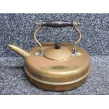 A Victorian brass kettle with wooden handle