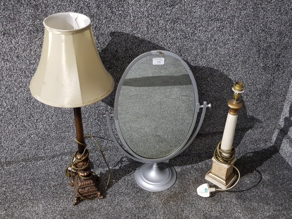 A grey painted metal swing mirror and two table lamps.
