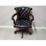 An adjustable Chesterfield captains chair, upholstered in leather, (ox blood colour)